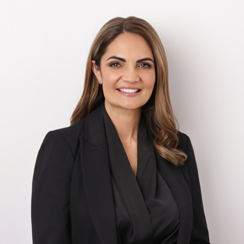 Woman in black blazer against plain light background